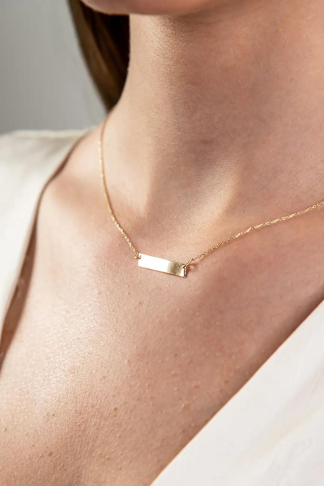 Zlatna ogrlica pličica nakrivljena